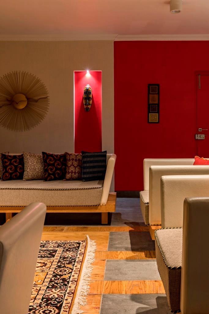 Living room detail with crimson accent wall and tribal mask niche